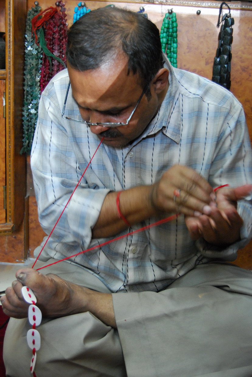 Anil Kumar threading Sandra Bowkett's necklace